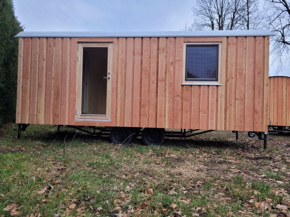 20 foot mobile trailer with door and window covered in wood