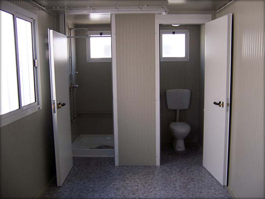 Cabine sanitaire avec toilettes séparées et douche indépendante